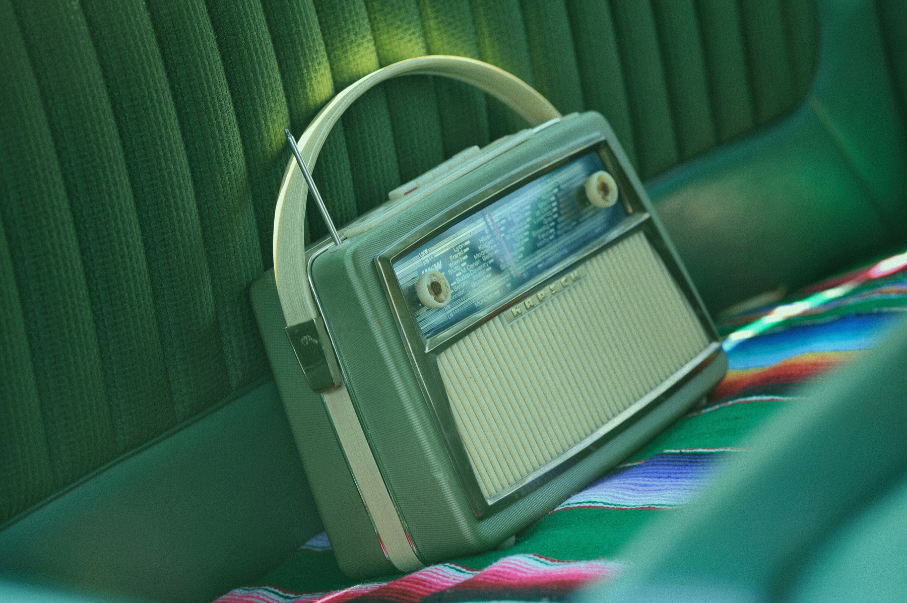 Een groene vintage radio op een bank