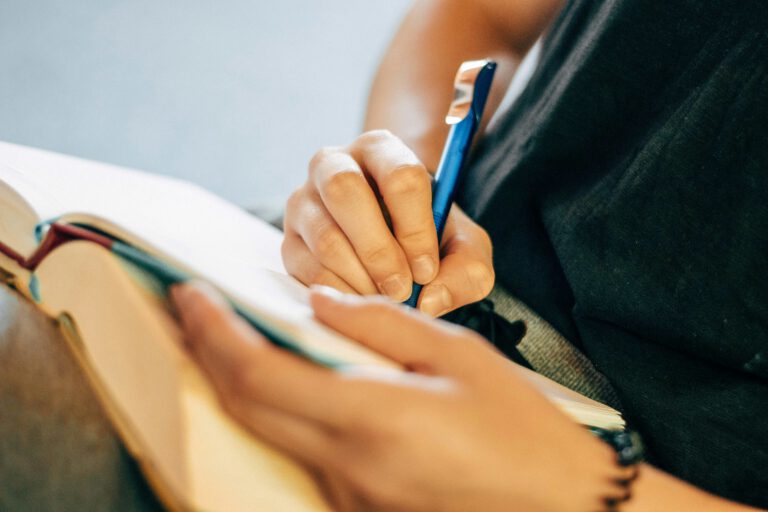 handen pen opengeslagen boek