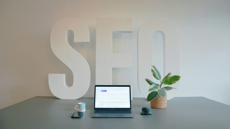 laptop op bureau en grote letters seo